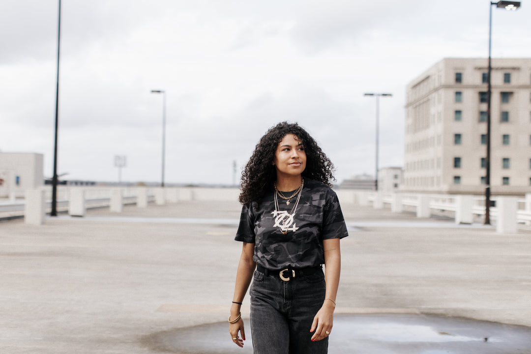 Woman in a camo 704 logo tee on a city parking deck