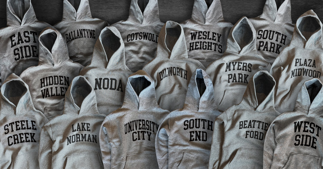 Gray Neighborhoodies printed with Charlotte neighborhood names, including NoDa, South End and Plaza Midwood